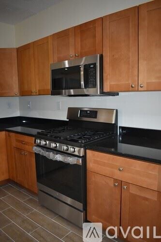 Boston apartment for rent - A kitchen with wooden cabinets and a black stove top.