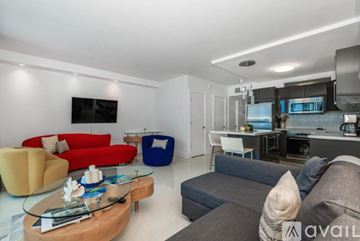 Miami Beach apartment for rent - A modern living room with a red sofa and a glass coffee table.