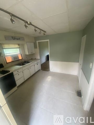 Struthers apartment for rent - A kitchen with white cabinets and a black dishwasher.