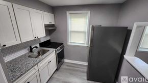 Baltimore apartment for rent - A kitchen with a black fridge and a sink.