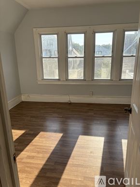 Milwaukee apartment for rent - A room with wooden flooring and a large window.
