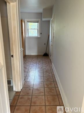 Milwaukee apartment for rent - A hallway with tiled flooring and a broom in the corner.