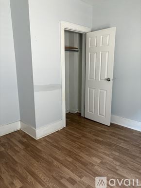 Milwaukee apartment for rent - A room with a white door and wooden floor.