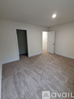 Angier house for rent - A bathroom with a toilet, sink, and mirror.