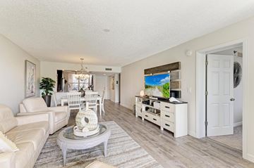Bradenton house for rent - A living room with a white couch, a coffee table, and a painting on the wall.