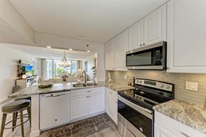 Bradenton house for rent - A kitchen with white cabinets and a granite countertop.