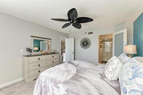 Bradenton house for rent - A bedroom with a large bed and a ceiling fan.