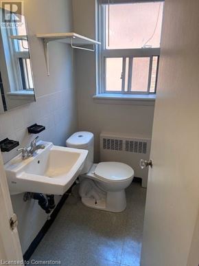 Hamilton apartment for rent - A bathroom with a toilet, sink, and window.