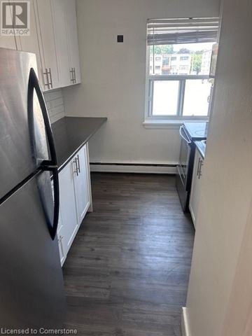 Dundas apartment for rent - A kitchen with a stainless steel refrigerator and wooden floors.