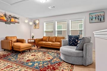 Apex house for rent - A living room with a rug and three chairs.