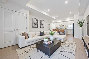 Kitchener apartment for rent - A modern living room with a white couch, a black coffee table, and a rug with a geometric pattern.