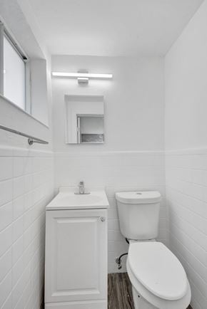 Bay Harbor apartment for rent - A white bathroom with a toilet, sink, and mirror.