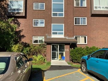 Halifax apartment for rent - A brown car is parked in front of a brick building with the number 23 on the door.