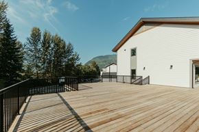 Revelstoke apartment for rent - A white building with a wooden deck in front.
