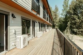 Revelstoke apartment for rent - A long wooden deck with air conditioning units on it.