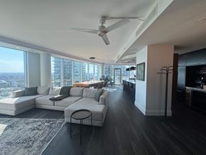Calgary apartment for rent - A modern living room with a large window overlooking the city.