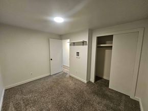 Nampa apartment for rent - A room with a carpeted floor and a doorway leading to another room.