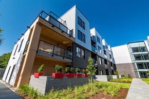 Halifax apartment for rent - A modern building with a balcony and a small garden in front.