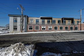 East Providence apartment for rent - A row of multi-story buildings with a clear blue sky above.