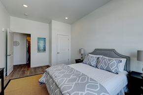East Providence apartment for rent - A bedroom with a large bed and a lamp.