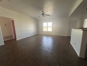 Killeen house for rent - A room with brown tile flooring and a ceiling fan.