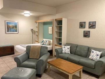 San Diego apartment for rent - A living room with a grey couch, a brown coffee table, and a grey chair.