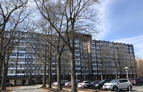 Washington apartment for rent - A large building with a parking lot in front of it.