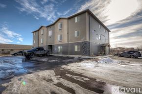 Rapid City apartment for rent - A large building with a parking lot in front of it.