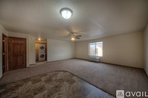Rapid City apartment for rent - A room with a ceiling fan and a window with blinds.