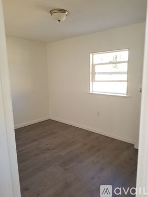 Pueblo house for rent - A room with a window and wooden flooring.