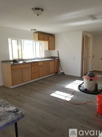 Pueblo house for rent - A kitchen with wooden cabinets and a concrete table.
