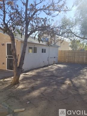 Pueblo house for rent - A small beige building with a green roof and a white door is in the foreground.
