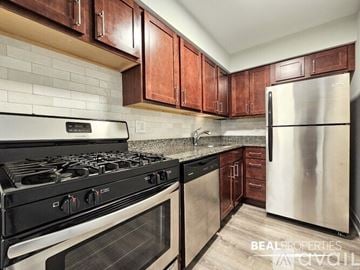 Chicago apartment for rent - A kitchen with a black stove top oven and a stainless steel refrigerator.