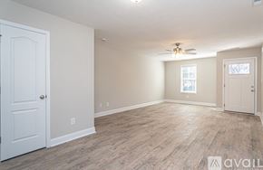 Fayetteville house for rent - A room with a white door and a window with a ceiling fan.
