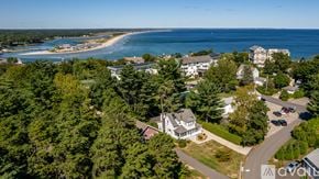 Ogunquit house for rent - A bird's eye view of a coastal area with a beach, buildings, and trees.