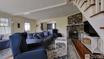 Ogunquit house for rent - A living room with a blue couch and a fireplace.