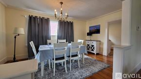 Ogunquit house for rent - A dining room with a table set for six with blue tablecloths and white chairs.