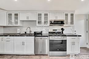 Los Angeles house for rent - A modern kitchen with white cabinets and stainless steel appliances.