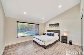 Los Angeles house for rent - A bedroom with a large bed and a window with blinds.