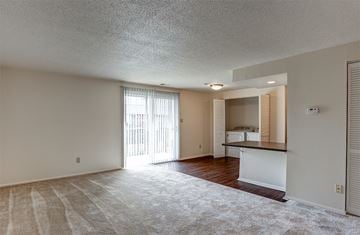 Ft. Wayne apartment for rent - A sparsely furnished living room with a sliding glass door leading to a balcony.