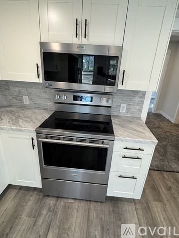 Eau Claire house for rent - A modern kitchen with a stainless steel oven and white cabinets.