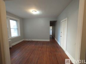 Baltimore apartment for rent - A room with wooden floors and two open doors.