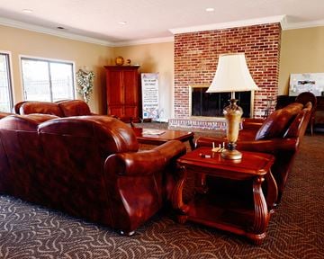 Mishawaka apartment for rent - a living room with leather furniture and a brick fireplace