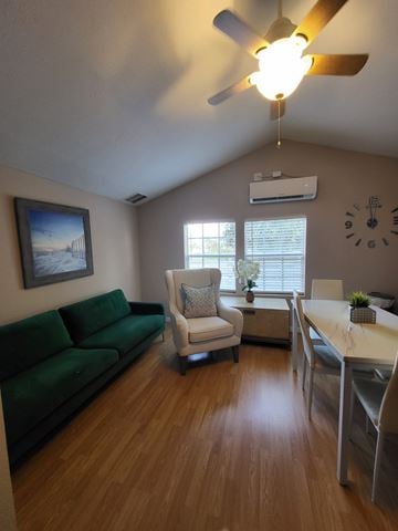 Lakeland apartment for rent - A living room with a green couch, a white chair, and a wooden floor.