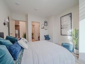 Edmonton apartment for rent - A bedroom with a large bed and a potted plant.