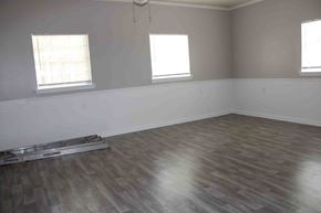 Hattiesburg apartment for rent - A room with wooden flooring and two windows.