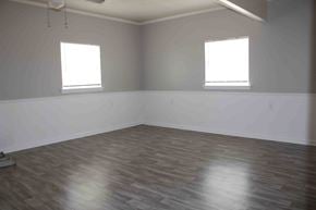 Hattiesburg apartment for rent - A room with wooden flooring and two windows.