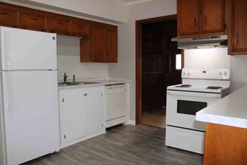 Hattiesburg apartment for rent - A kitchen with white appliances and wooden cabinets.