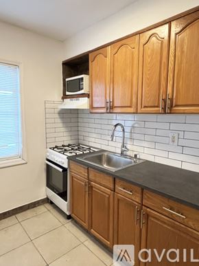 Miami apartment for rent - A kitchen with wooden cabinets and a white stove top oven.