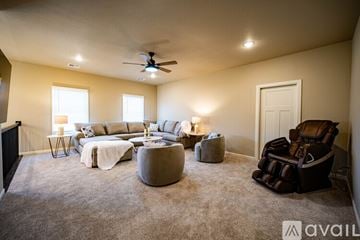 Jenks house for rent - A living room with a brown chair and a grey ottoman.